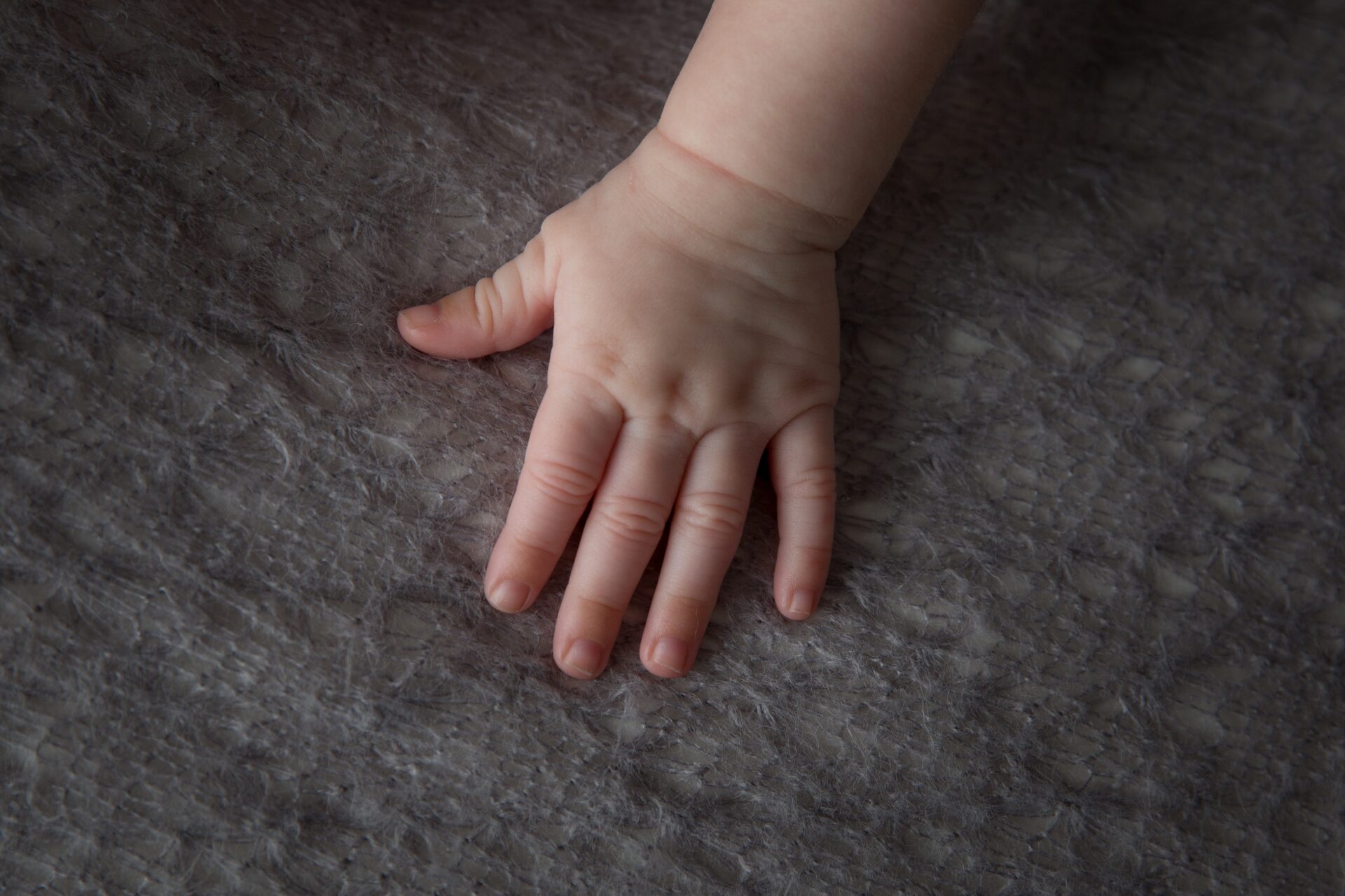 high angle shot of the soft and chubby hand of a baby on a fluffy cloth
