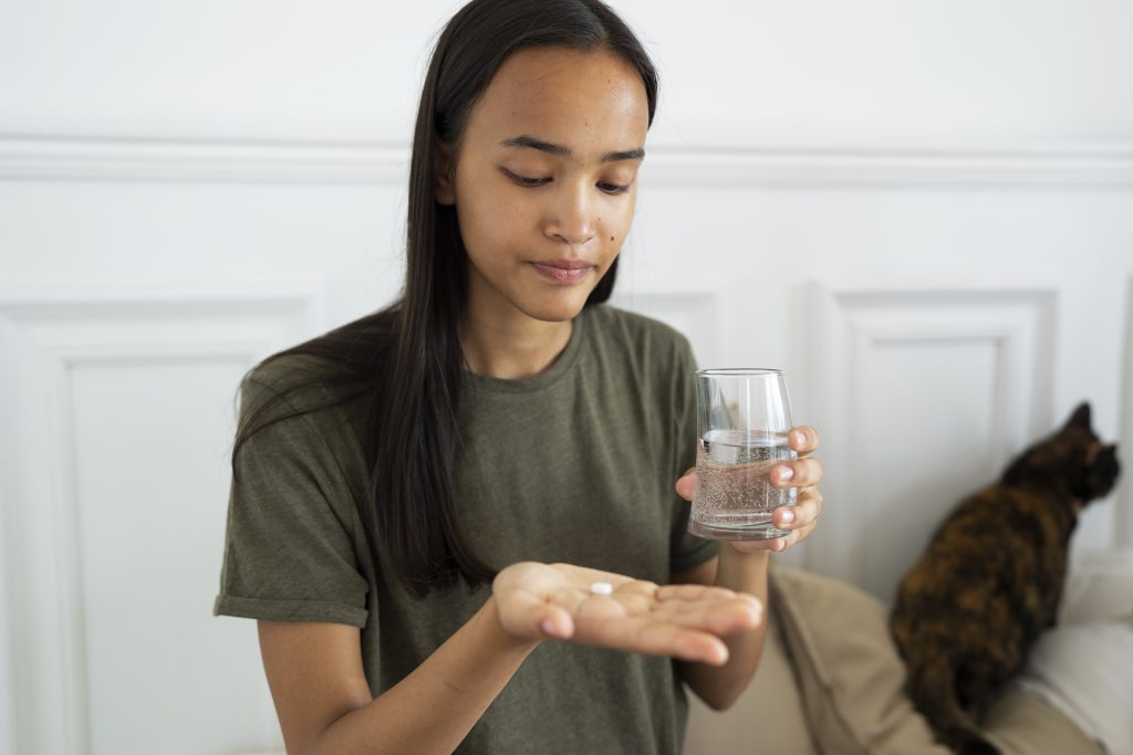 medium shot woman holding pill 1024x683